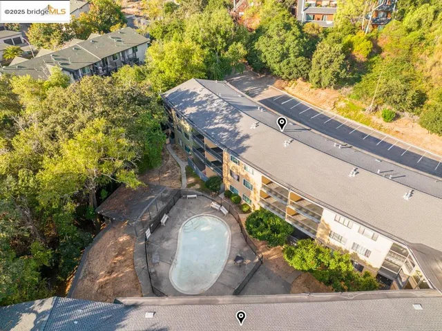 an aerial view of a house with a yard and a large tree