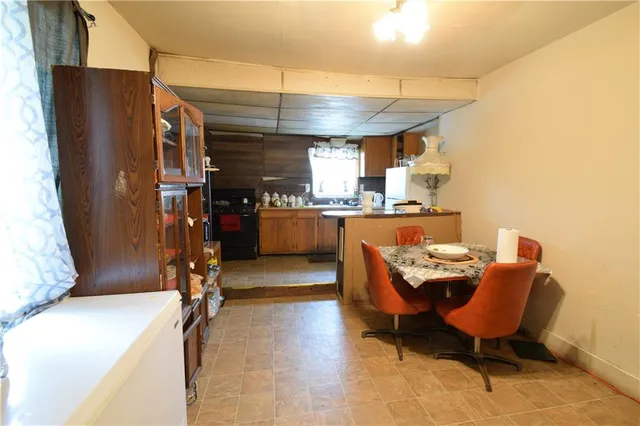 a room with stainless steel appliances kitchen island granite countertop furniture and a refrigerator