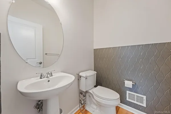 a bathroom with a sink a toilet and mirror