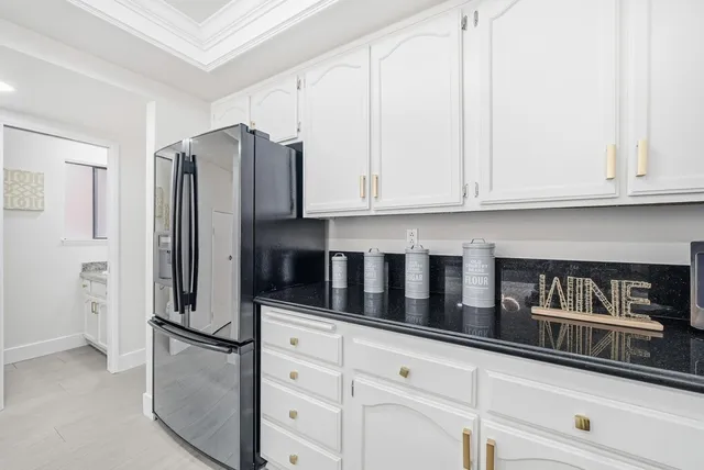 a kitchen with stainless steel appliances white cabinets and a refrigerator