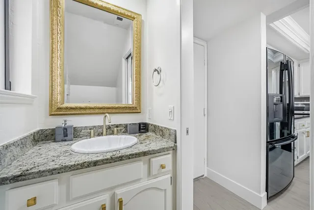 a bathroom with a granite countertop sink and a mirror