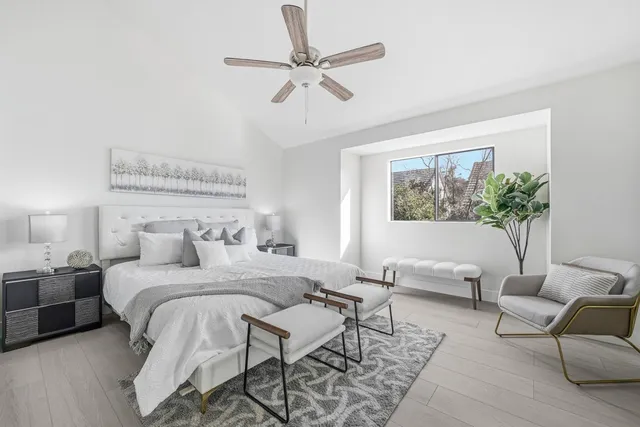 a bedroom with a large bed couch and a window