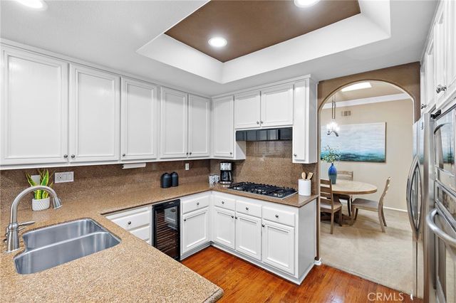 a kitchen with stainless steel appliances granite countertop a sink a stove and cabinets