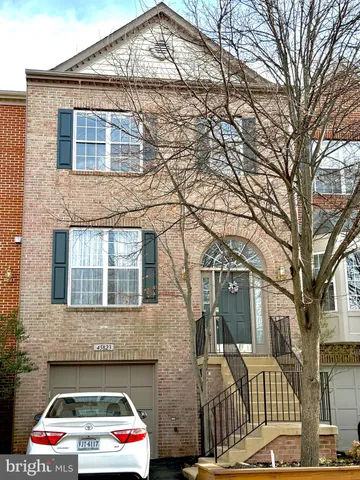 a white house that has tree in front of it