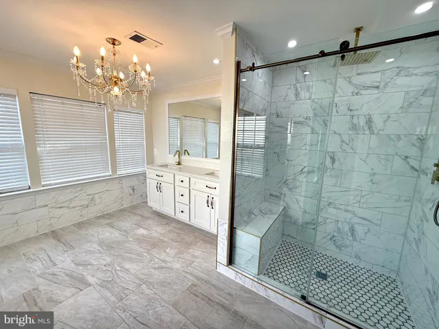a bathroom with a granite countertop shower a sink and a mirror