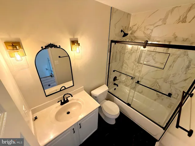 a bathroom with a sink mirror vanity and toilet
