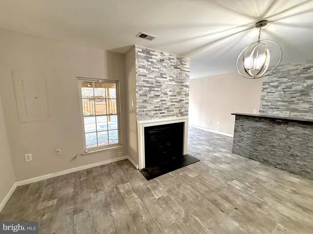 an empty room with windows and fireplace