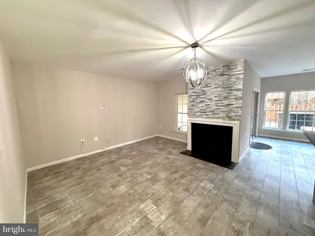an empty room with windows and fireplace