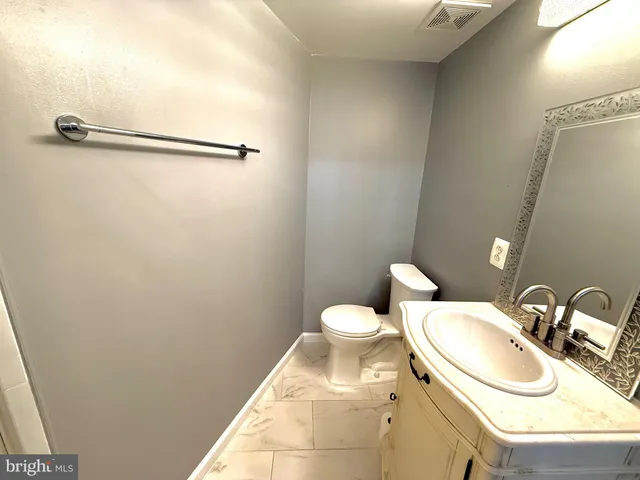 a bathroom with a sink toilet and mirror