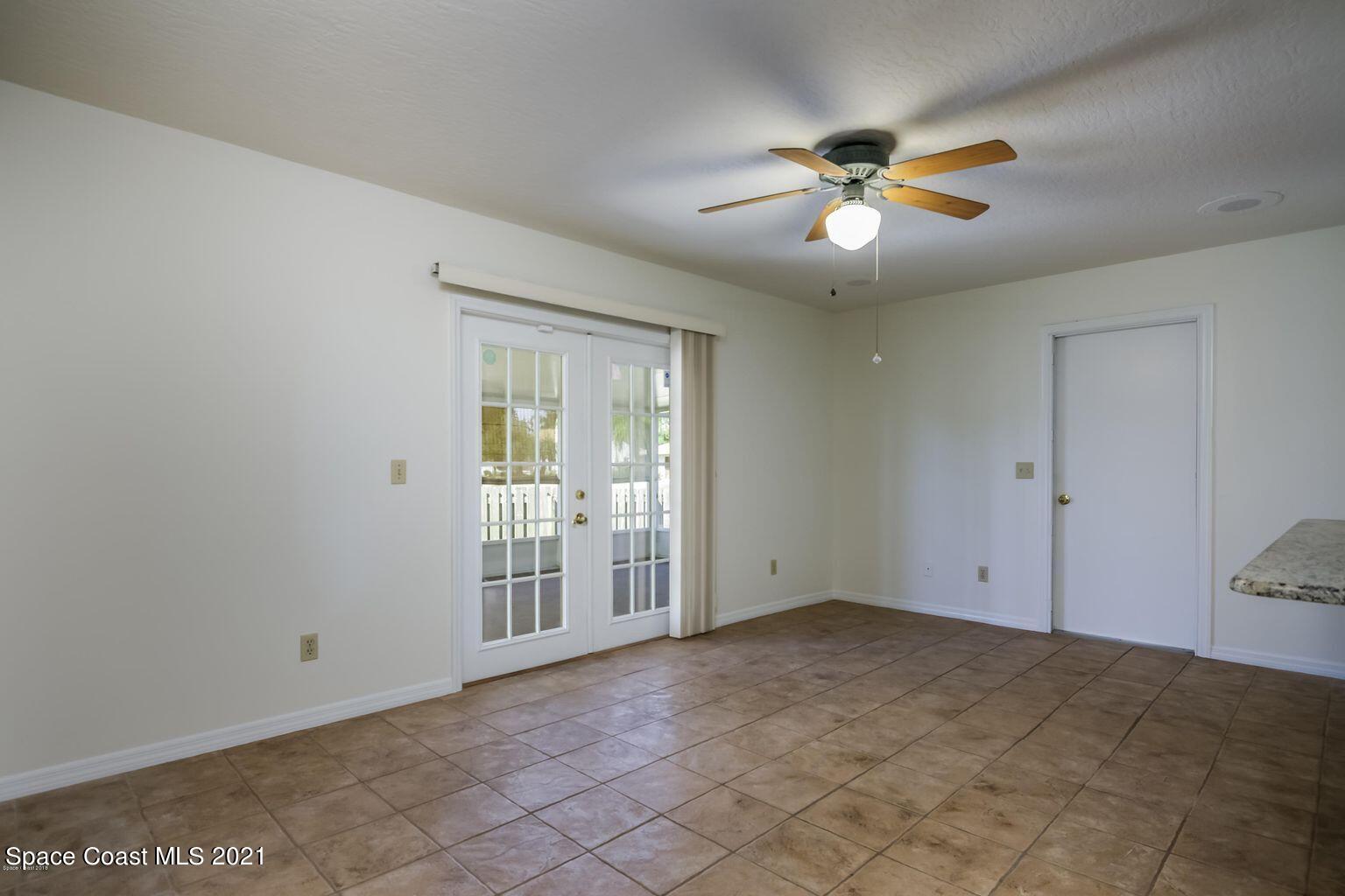 376 Trier Road Northwest Palm Bay, FL 32907 - Photo 11 of 16 an empty room with chandelier fan and windows
