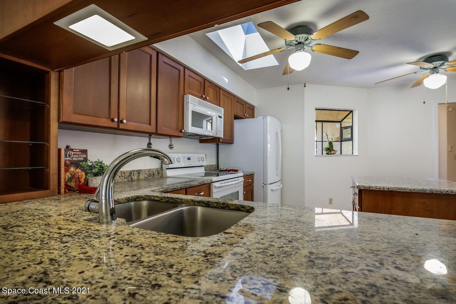 376 Trier Road Northwest Palm Bay, FL 32907 - Photo 3 of 16 a kitchen with stainless steel appliances granite countertop a sink a stove and a microwave