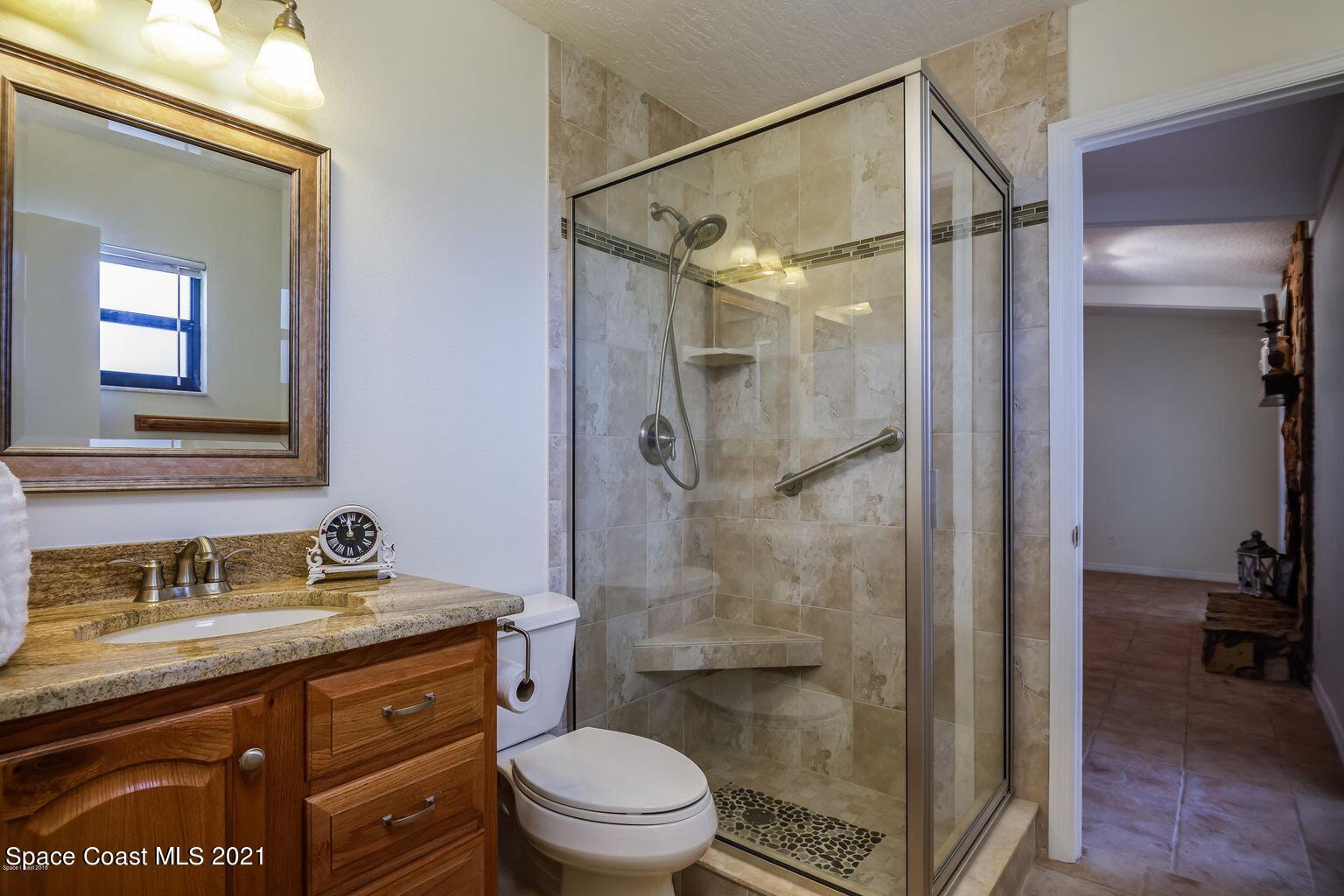 376 Trier Road Northwest Palm Bay, FL 32907 - Photo 10 of 16 a bathroom with a granite countertop sink toilet and shower