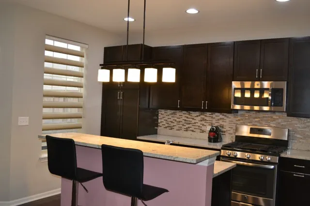 a kitchen with granite countertop a stove and a microwave