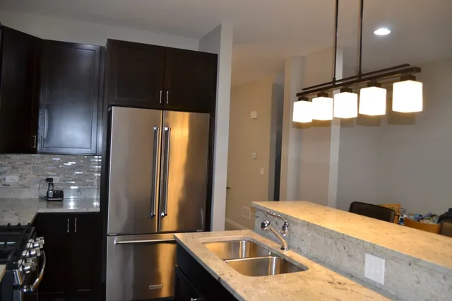 a kitchen with stainless steel appliances granite countertop a refrigerator and a sink