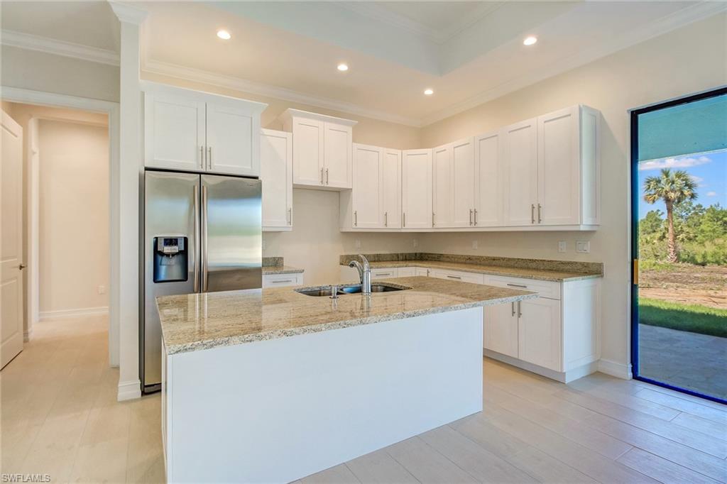873 18th Street Northeast Naples, FL 34120 - Photo 4 of 18 a kitchen with stainless steel appliances granite countertop a refrigerator and a sink