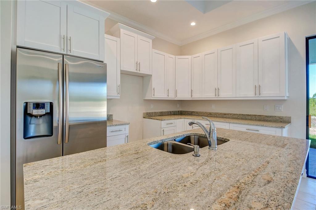 873 18th Street Northeast Naples, FL 34120 - Photo 5 of 18 a kitchen with a refrigerator sink and cabinets