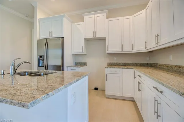 a kitchen with stainless steel appliances granite countertop a sink and a refrigerator
