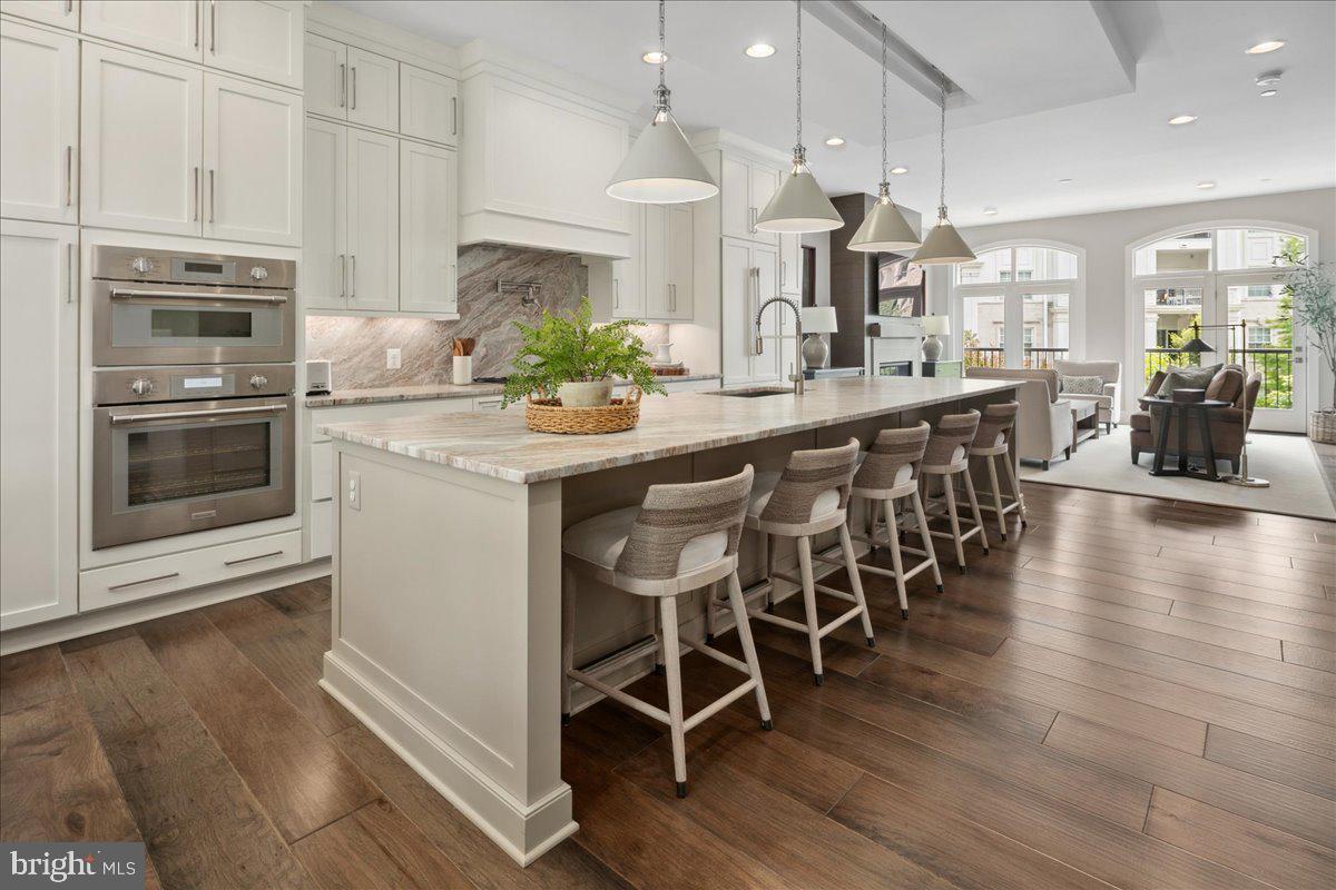 8129 River Road Bethesda, MD 20817 - Photo 14 of 84 a kitchen with stainless steel appliances kitchen island granite countertop a table chairs sink and cabinets