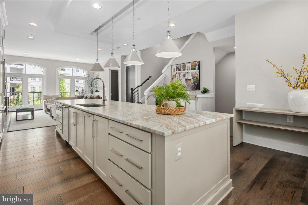 8129 River Road Bethesda, MD 20817 - Photo 15 of 84 a large kitchen with stainless steel appliances kitchen island a large counter top a stove a chimney a sink and a large window