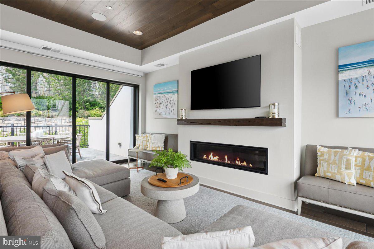8129 River Road Bethesda, MD 20817 - Photo 52 of 84 a living room with furniture a fireplace and a flat screen tv