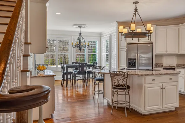 a kitchen with stainless steel appliances granite countertop a sink a stove and a wooden floors