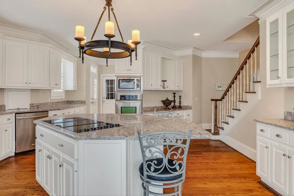 a kitchen with stainless steel appliances granite countertop a sink and a refrigerator
