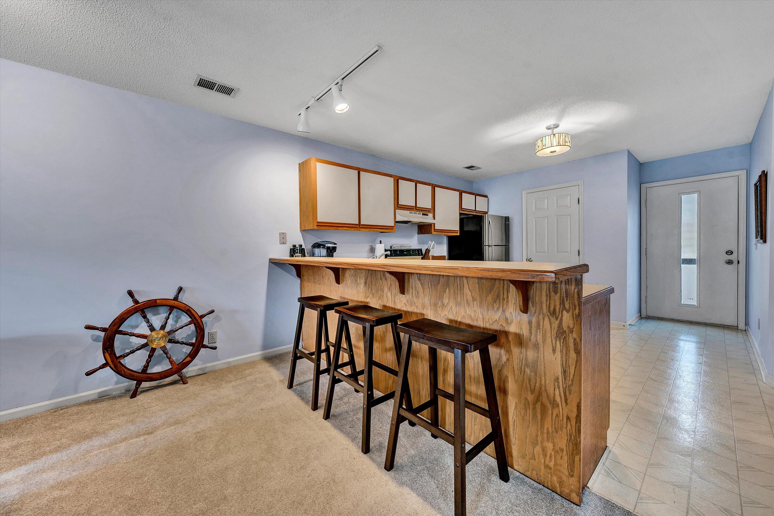 600 Monte Vista Road, Unit 802 Union Hall, VA 24176 - Photo 11 of 32 a kitchen with stainless steel appliances kitchen island granite countertop a dining table chairs and a refrigerator