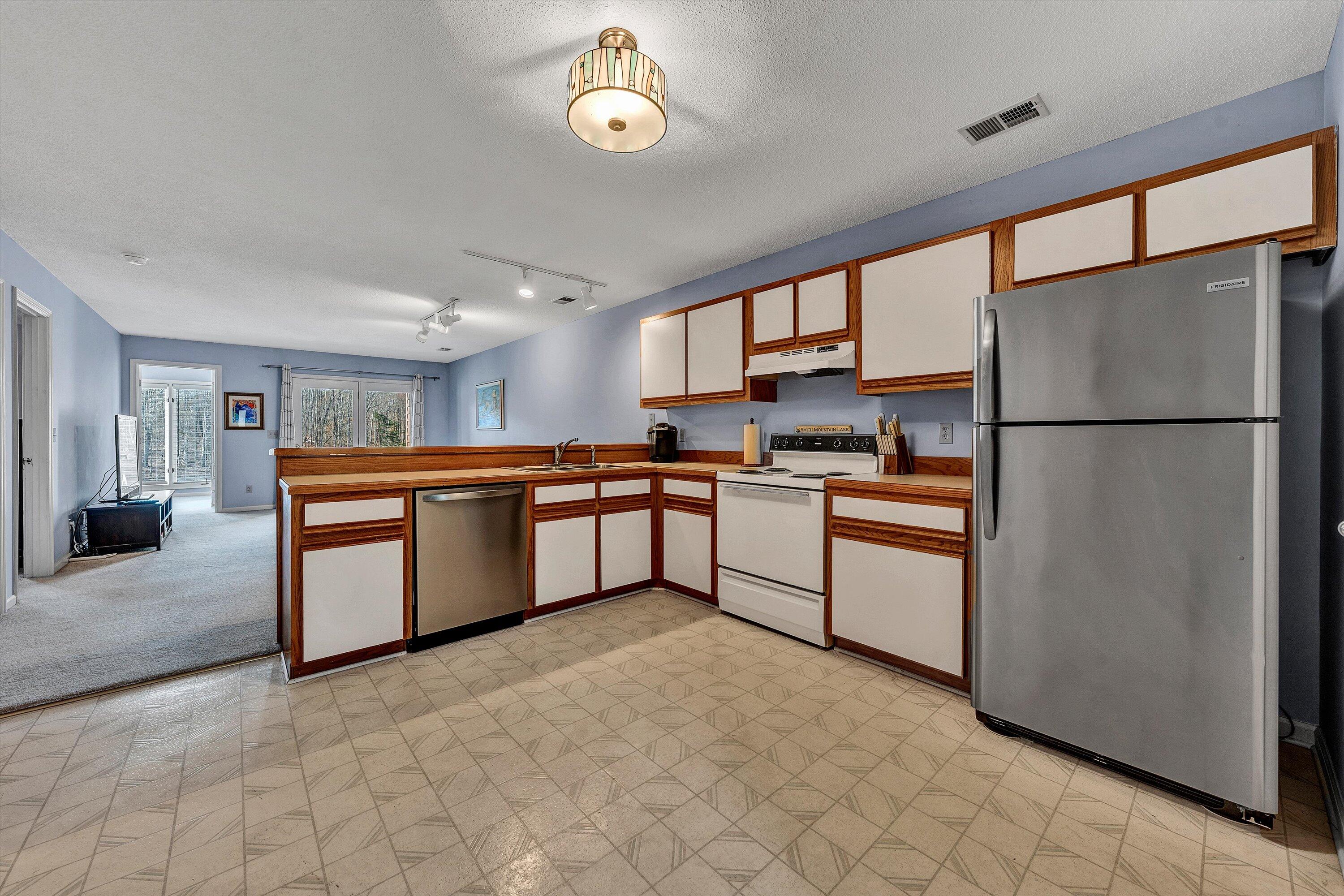 600 Monte Vista Road, Unit 802 Union Hall, VA 24176 - Photo 6 of 32 a kitchen with granite countertop a refrigerator a sink and white cabinets