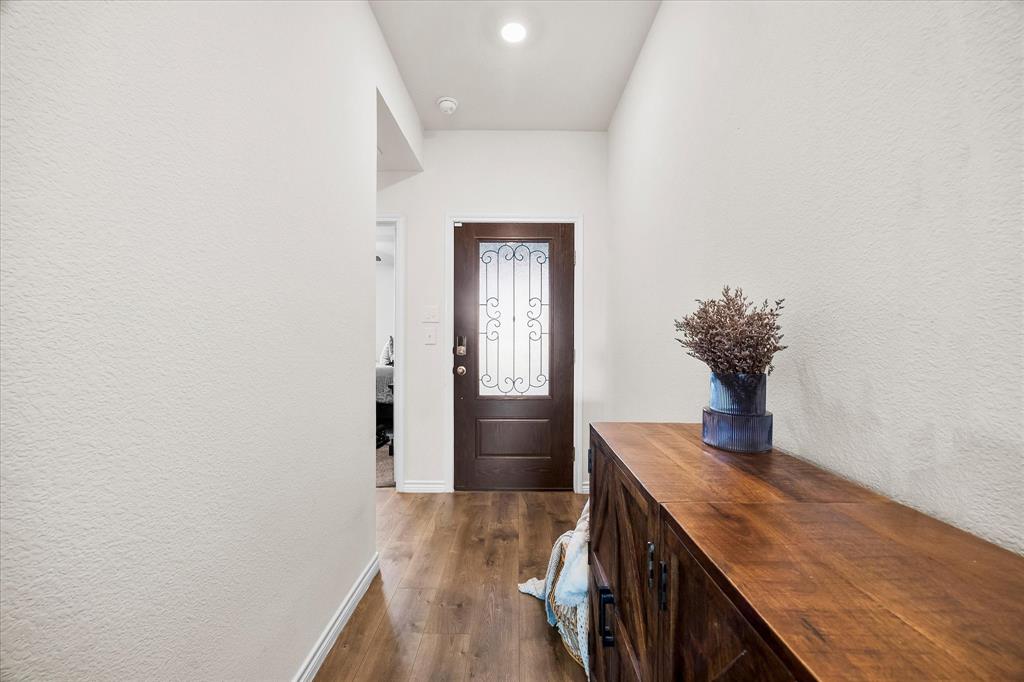 1003 Stage Coach Lane Princeton, TX 75407 - Photo 4 of 26 a hallway with wooden floor wooden cabinets and entryway