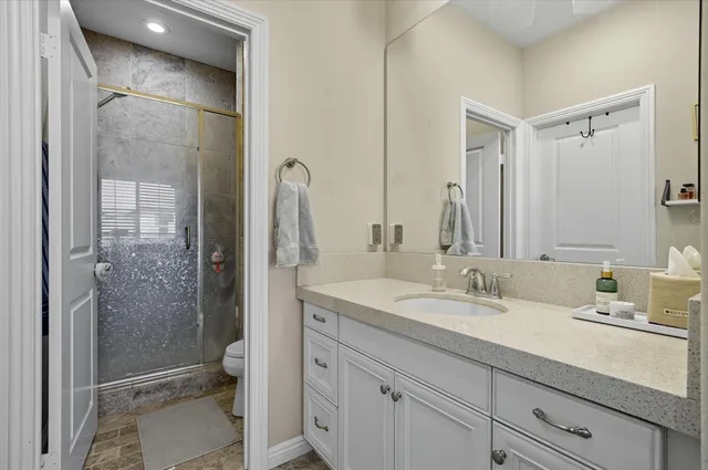 a bathroom with a shower sink vanity and mirror
