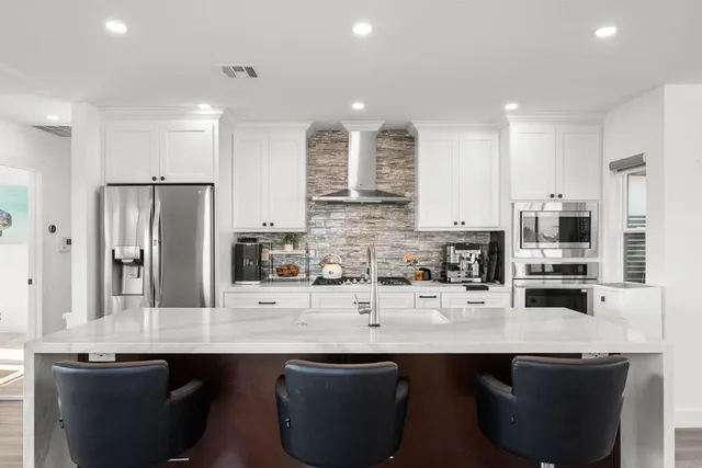 a view of a living room and kitchen with furniture wooden floor and a large window
