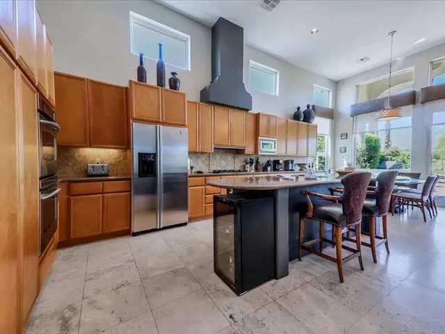 a kitchen with stainless steel appliances a sink counter top space cabinets and a window