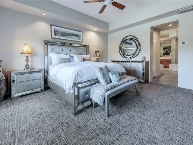 a bedroom with a bed and a flat tv screen on wall