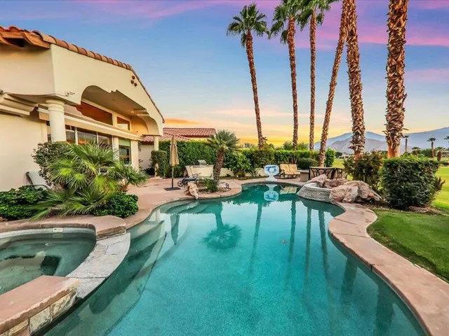 a front view of a house with swimming pool having outdoor seating