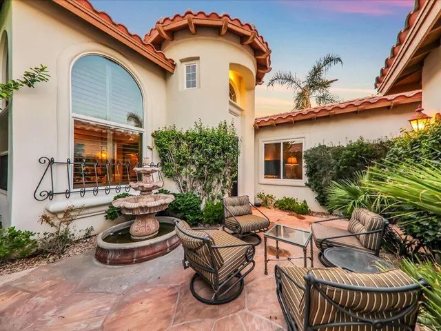 a view of a patio with couches table and chairs and potted plants