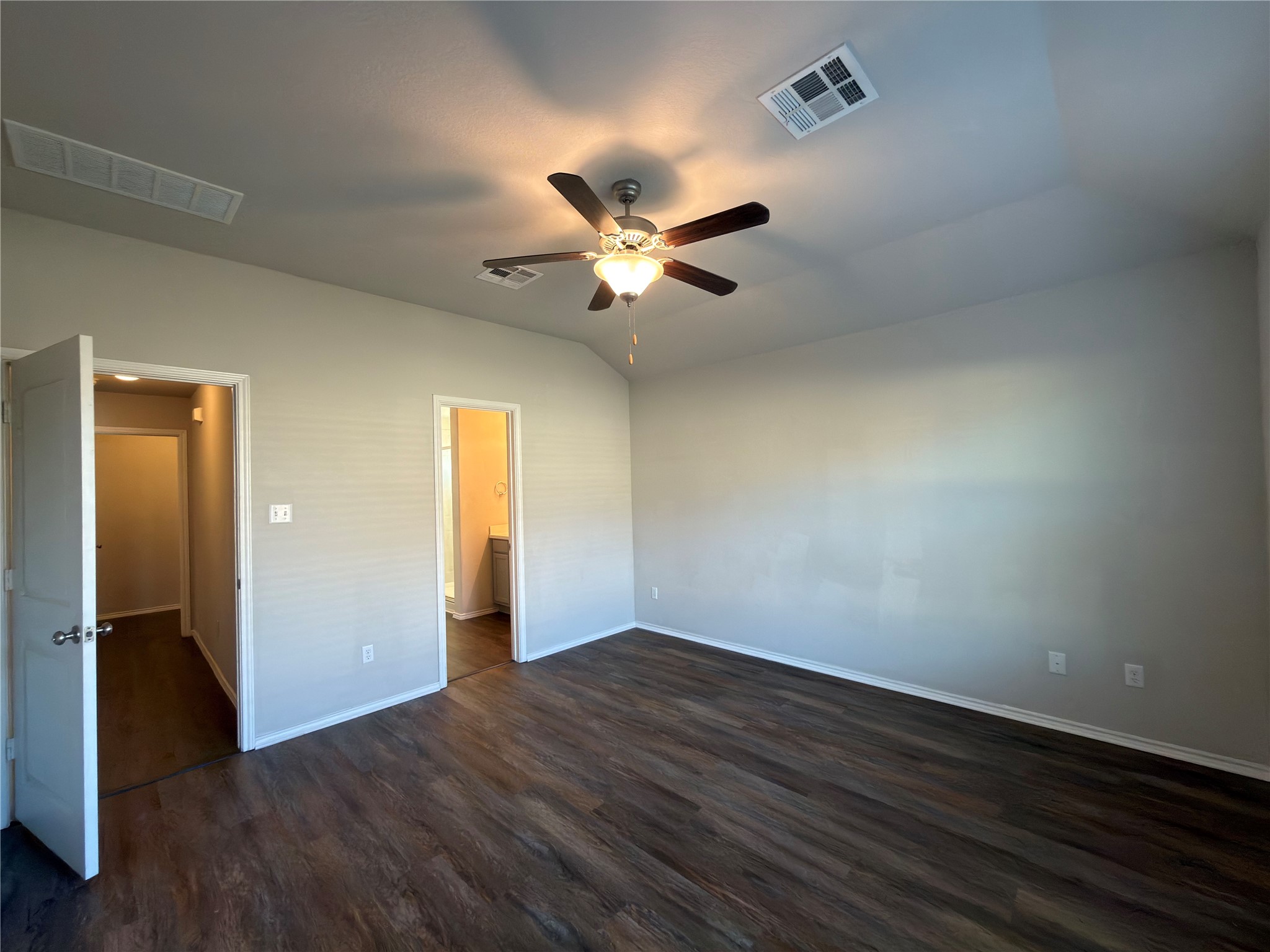 21700 Urraca Lane Pflugerville, TX 78660 - Photo 13 of 40 Unfurnished bedroom with dark wood-type flooring, ceiling fan, lofted ceiling, and connected bathroom