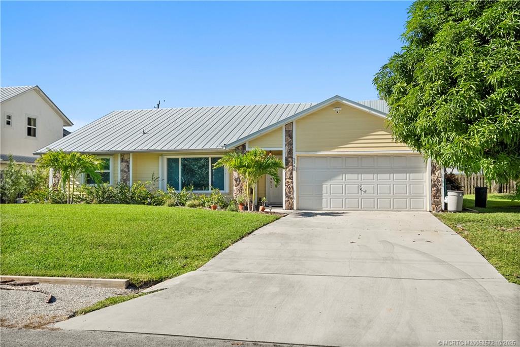 a front view of a house with a yard and potted plants