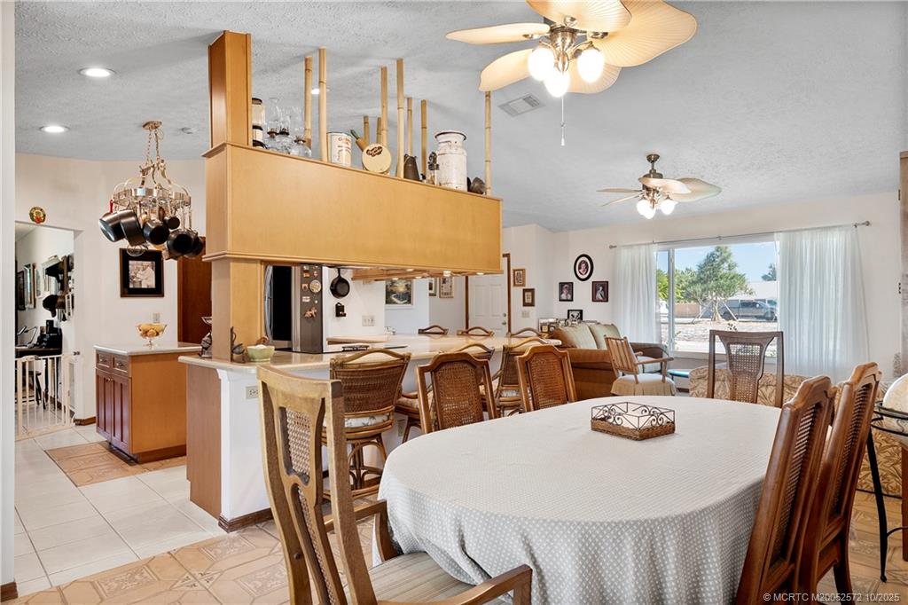 5145 Southeast Matousek Street Stuart, FL 34997 - Photo 12 of 52 a view of a dining room with furniture and chandelier