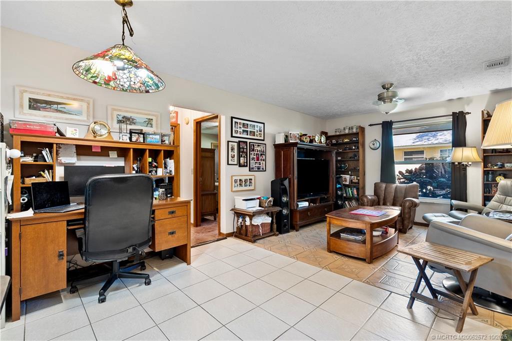 5145 Southeast Matousek Street Stuart, FL 34997 - Photo 14 of 52 a living room with patio furniture and a chandelier
