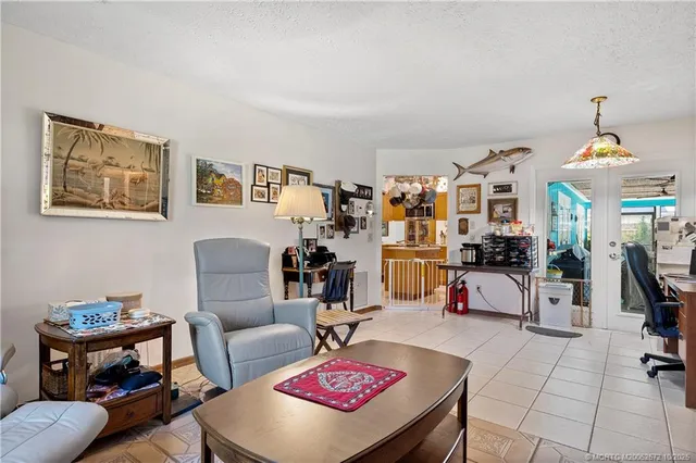 a living room with furniture a dining table and a chandelier