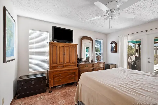a bedroom with a bed and a flat tv screen on dresser