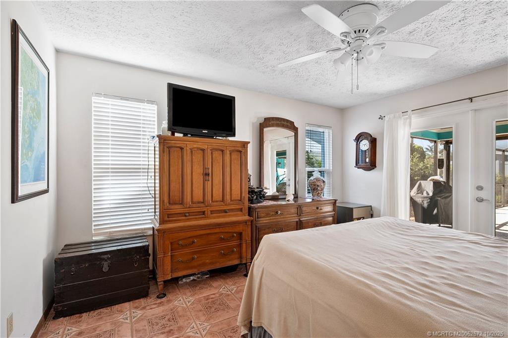 5145 Southeast Matousek Street Stuart, FL 34997 - Photo 17 of 52 a bedroom with a bed and a flat tv screen on dresser