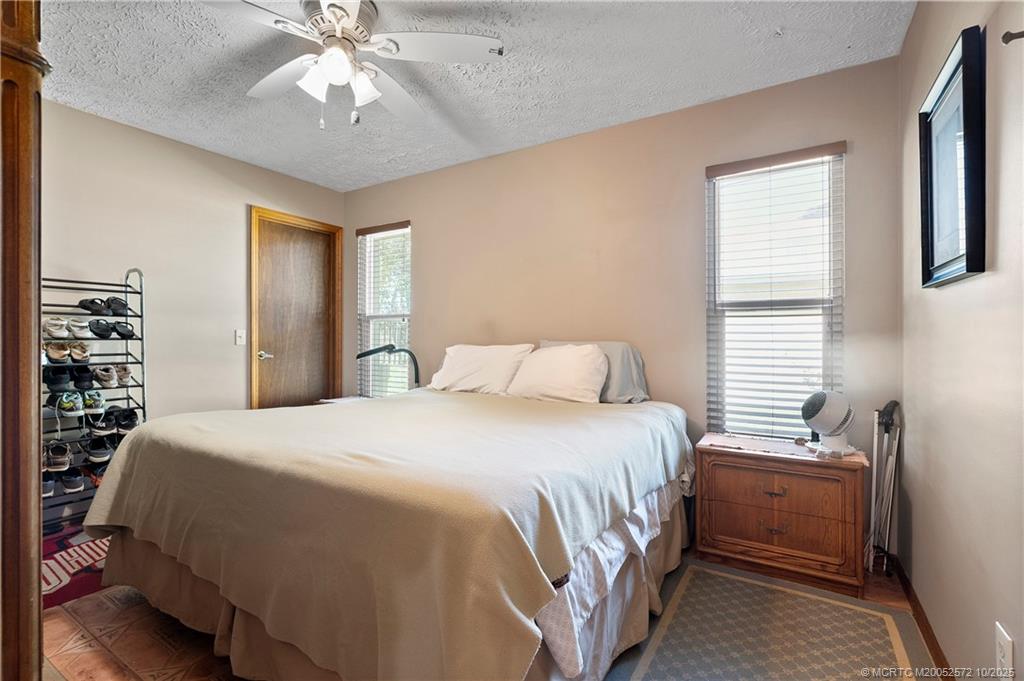 5145 Southeast Matousek Street Stuart, FL 34997 - Photo 20 of 52 a bedroom with a bed and a chandelier