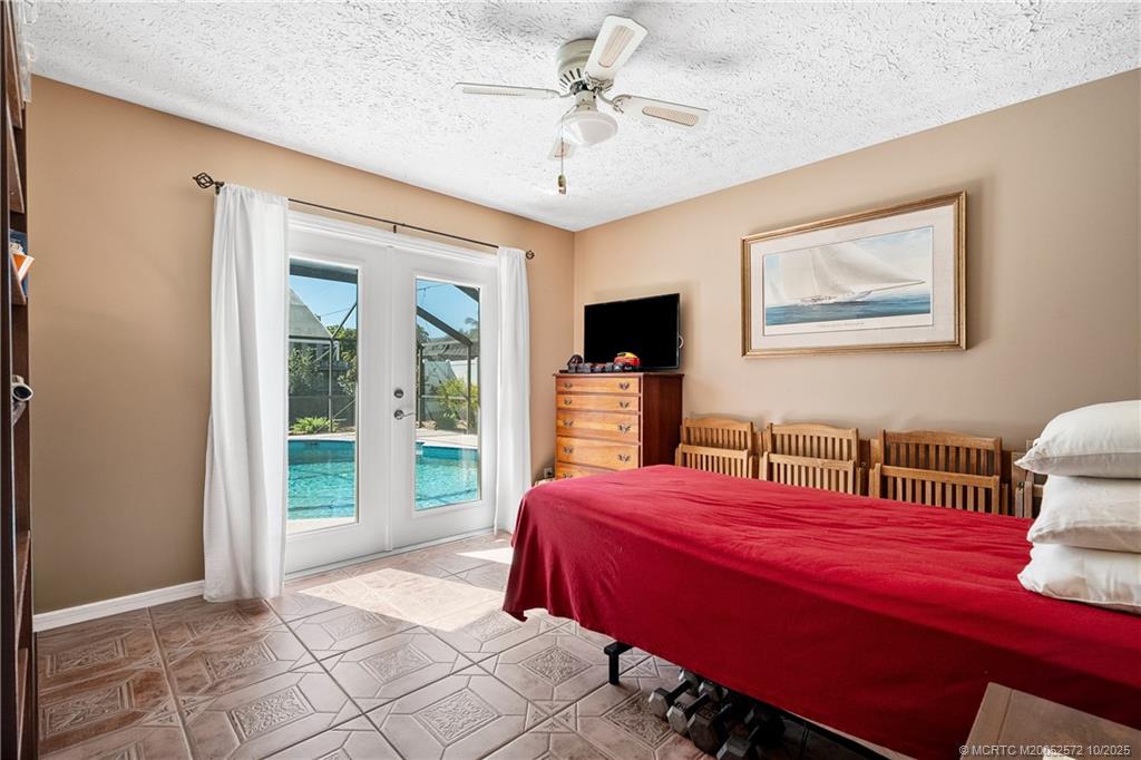 5145 Southeast Matousek Street Stuart, FL 34997 - Photo 21 of 52 a bedroom with a bed and a chandelier