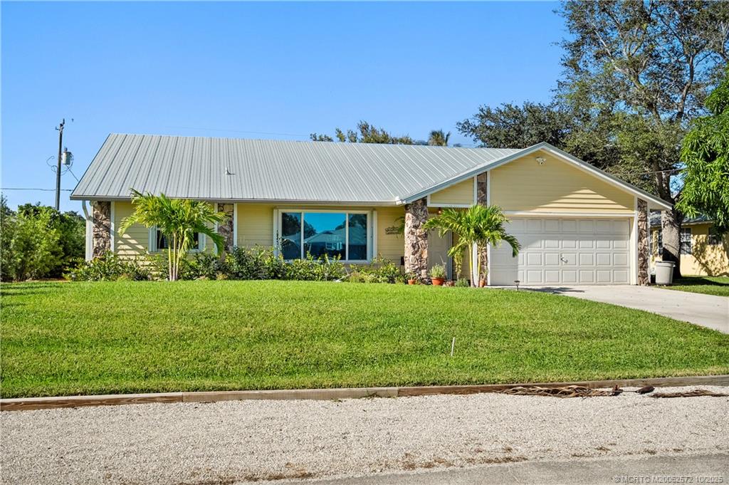 5145 Southeast Matousek Street Stuart, FL 34997 - Photo 34 of 52 a front view of a house with a garden