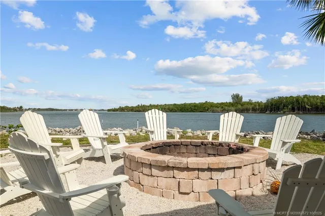 a view of a lake with table and chairs