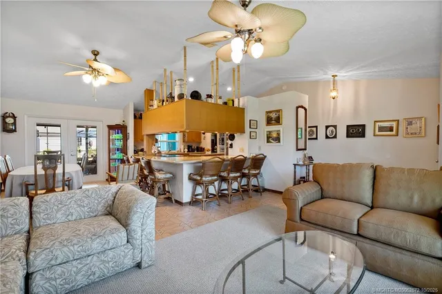 a living room with furniture kitchen view and a chandelier