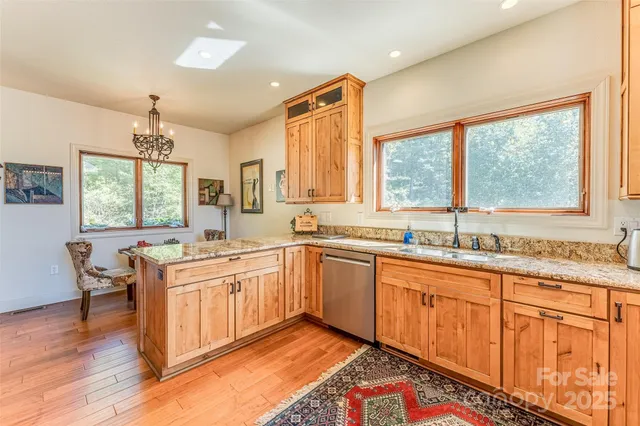 a kitchen with stainless steel appliances granite countertop sink window and cabinets