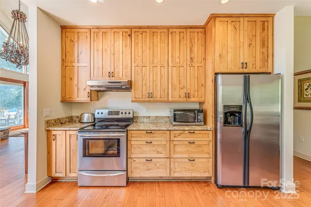 a kitchen with stainless steel appliances granite countertop a refrigerator sink and stove