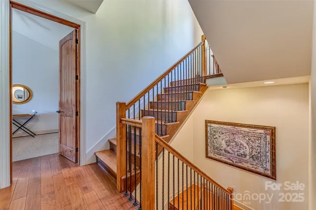 a view of staircase with wooden floor and paintings on the walls